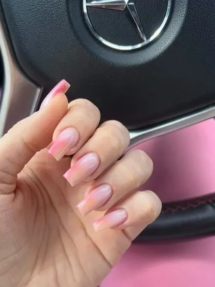 A soft and pretty peach-toned ombré on long, coffin-shaped nails, creating a warm and delicate look.