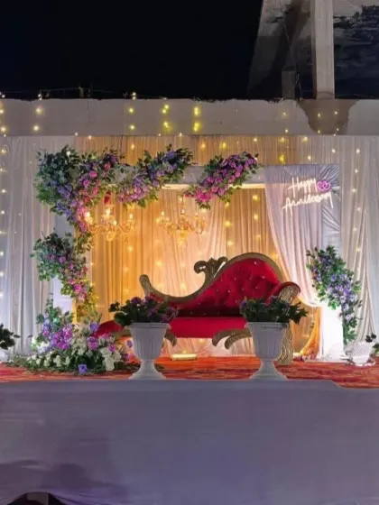 A full view of the outdoor anniversary stage, illuminated by fairy lights against the night sky.