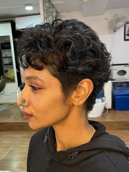 Meghna's curly pixie, a perfect example of a short, stylish cut for naturally curly hair.