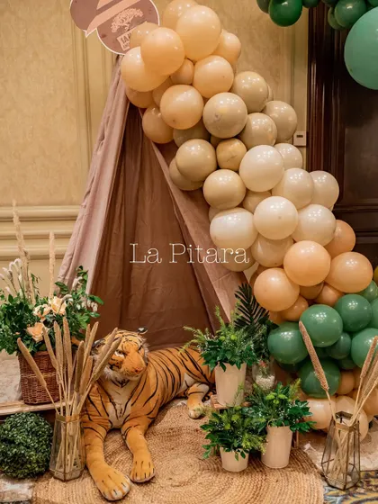 A cozy safari tent setup with a plush tiger and a balloon garland, creating a perfect little hideaway for kids.