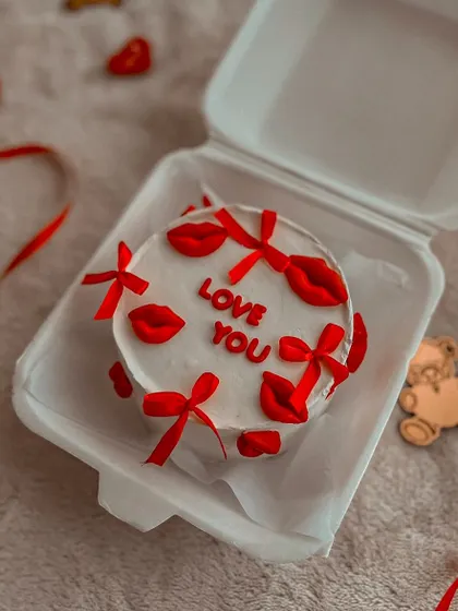 A cute "Love You" bento cake, perfect for Valentine's Day. This mini cake is decorated with tiny red bows and lipstick kisses.