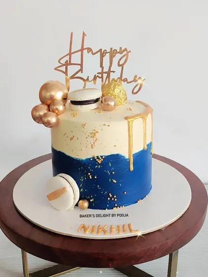 Another take on a classy cake for men, this design features a blue and white base with gold drip, macarons, and chocolate spheres. It's modern, elegant, and delicious.
