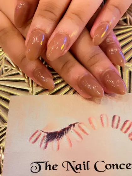 A classic set of almond-shaped nails in a warm, caramel nude color. The glossy finish gives it a polished and sophisticated look.