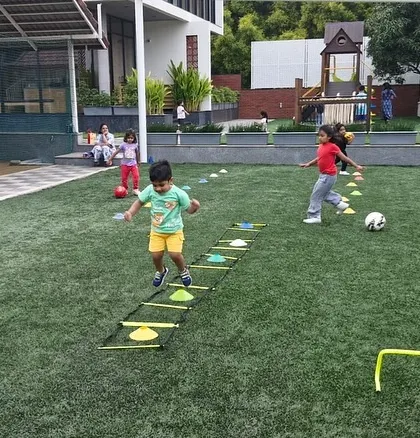 A child hops through an agility ladder, a key exercise for improving foot speed and coordination. Our drills are designed to build a strong athletic foundation.