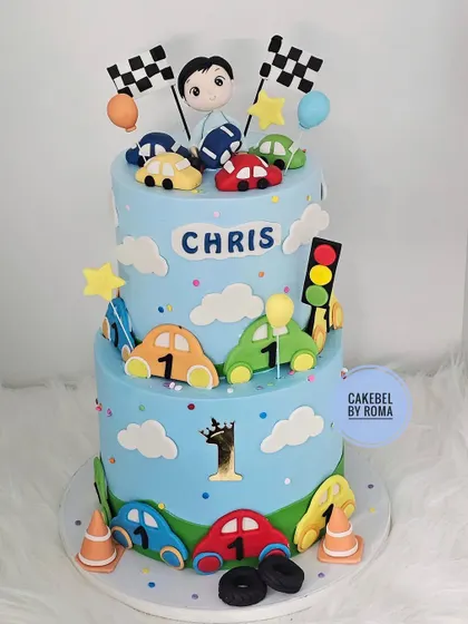 A full view of the two-tier car cake against a clean background.