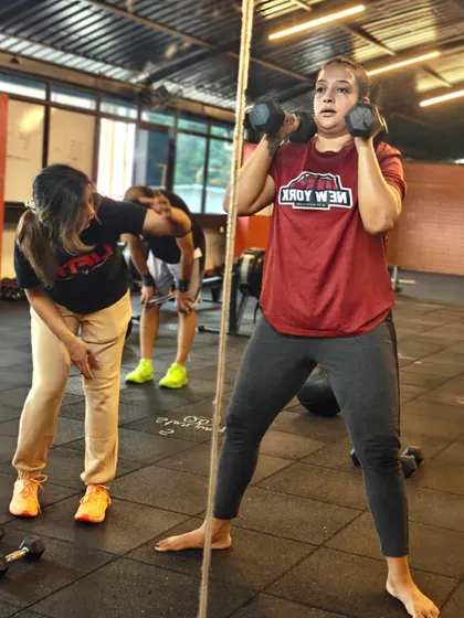 The coach-to-member ratio is key. Here you can see our coaches providing on-the-floor assistance, correcting form during weighted sit-ups and hip thrusts, and ensuring every member gets the attention they need.