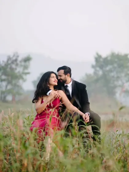 An intimate moment nestled in the tall grass by the lake. The natural elements frame the couple, making the scene feel private and romantic.