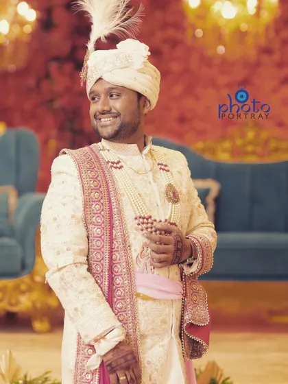 A handsome portrait of the groom in his wedding sherwani, capturing his happiness and style.