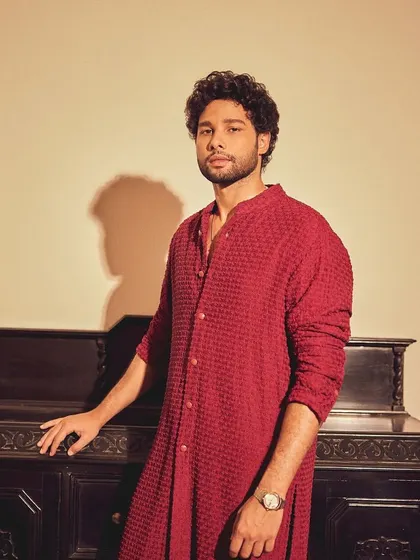 A three-quarter shot of Siddhant, showing the rich texture and vibrant color of the Kunal Rawal kurta.