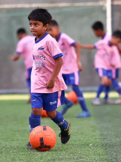 A young player focuses on his dribbling at the BFC Summer Camp in Pune.