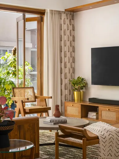 This introductory shot of 'Palaash' shows the custom wood and glass door leading to the balcony, a recreation of a classic French door that adds immense warmth and character to the living space.