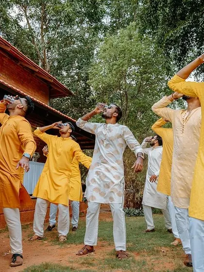 The groom's friends share a drink and a laugh during the Haldi celebrations.