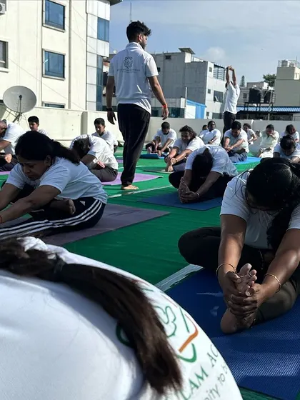 A close-up of students in Paschimottanasana (Seated Forward Bend), a deep stretch that encourages introspection and surrender.