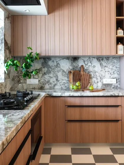 In this kitchen, the warmth of fluted wood cabinetry is paired with a striking marble backsplash. The result is a space that feels both organic and sophisticated, with clean lines and natural patterns creating a balanced, modern aesthetic.