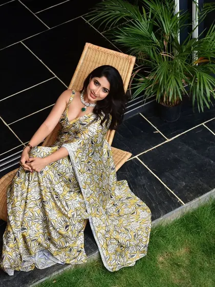 A full shot showing how this contemporary jewellery choice elevates the simple, elegant saree.
