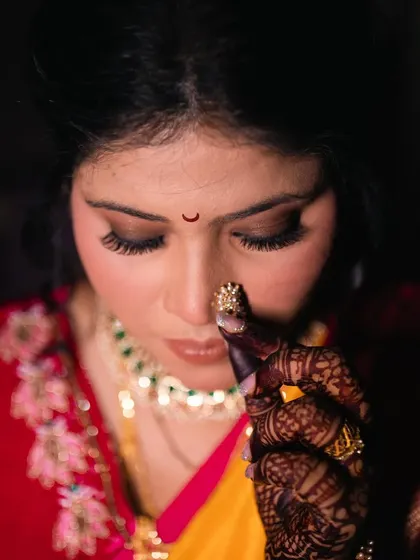 The bride adjusting her nath, a classic pose that captures the essence of Maharashtrian bridal beauty.