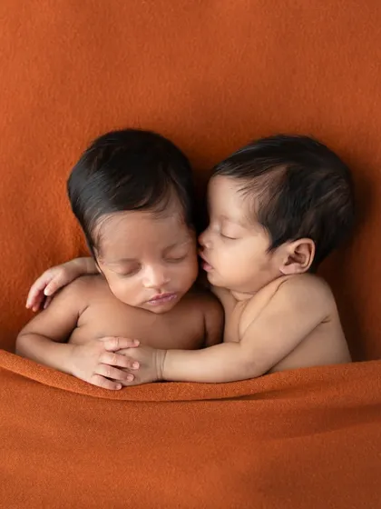 What do you think she's whispering? This adorable portrait of newborn twins invites you to imagine the secret conversations happening between them.