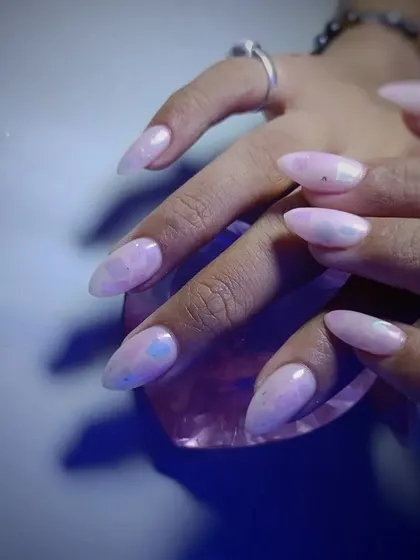 A set of "glass" nails, which have a translucent, jelly-like appearance. This set is a soft pink with subtle iridescent flakes inside.