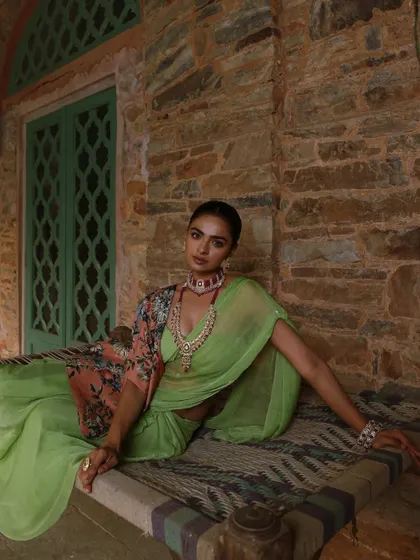 A serene yet opulent look from a heritage jewellery campaign. I styled a lime green saree with a floral cape and a stunning ruby choker and necklace set, creating a beautiful contrast against the rustic stone architecture.