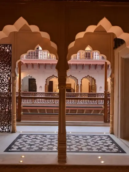 The corridor railings are contemporary versions of the haveli's historical design, made of wood and painted GI balustrades. They create a beautiful play of light and shadow on the white stone floors.