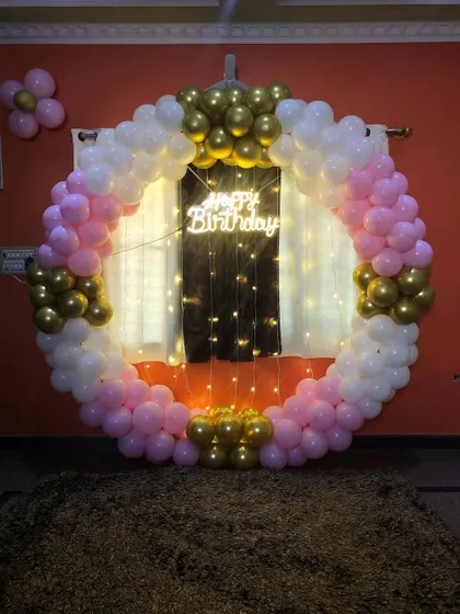 A simplified version of the pink, white, and gold theme, focusing on the balloon ring with a neon sign and fairy lights.