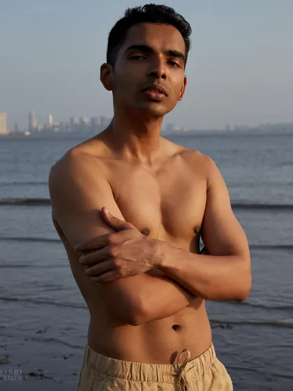 A strong and confident beach portrait with the Mumbai skyline in the background. This shot combines natural beauty with an urban edge, perfect for a model's portfolio.