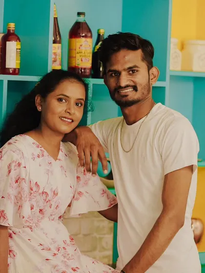 A casual and sweet portrait of a couple in a colorful, cafe-like setting.