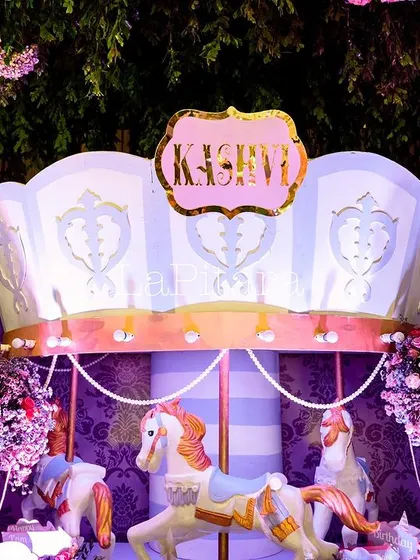 A stunning carousel prop decorated with flowers and butterflies, a centerpiece of the enchanted garden theme.