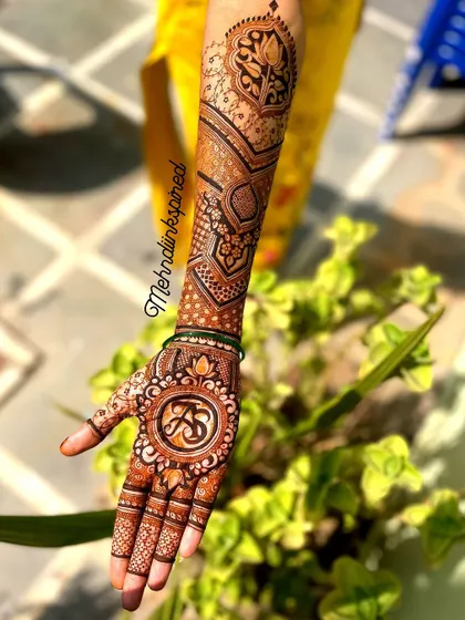 A full view of the personalized initial mehndi. The design flows beautifully up the arm with modern geometric patterns, keeping the focus on the custom monogram.