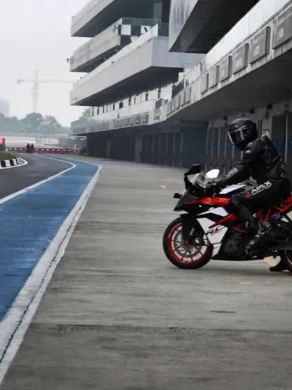 A quiet moment in the pit lane at Buddh International Circuit. A rider sits on their KTM, ready for the next session, with the empty track waiting.
