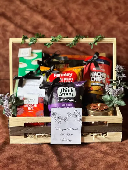 Another angle of the snack-filled engagement hamper. The "Congratulations On Your Wedding" card adds a personal touch to the gift.