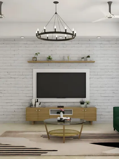 A rustic-modern living room featuring a simple wooden TV stand against a white brick wall. Floating shelves above the TV provide space for books and decor, creating a relaxed, eclectic vibe.
