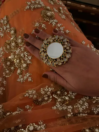 A close-up of my accessories for the palace wedding. A statement mirror-work ring adds a contemporary touch to the traditional saree.