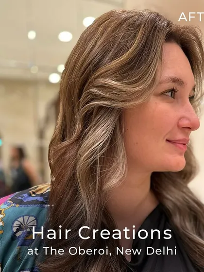 A profile view of the cool ash colour, showing how the curtain bangs and waves frame the face and highlight the custom tones.