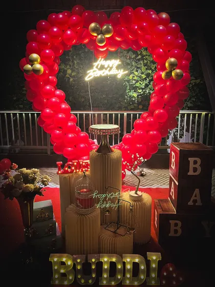 A romantic birthday surprise with a red heart-shaped balloon arch, perfect for celebrating your partner.