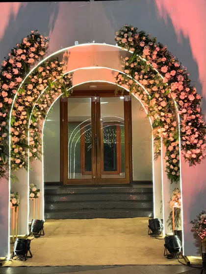 Another angle of the illuminated floral arches, showing the warm glow they cast. This type of entrance is perfect for setting a romantic mood for a reception or engagement party.