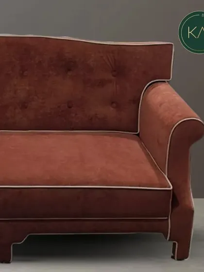 A close-up view of a classic sofa upholstered in a rich terracotta fabric with contrasting white piping. This detail shot highlights the precision of our upholstery work and the quality of the materials we use.