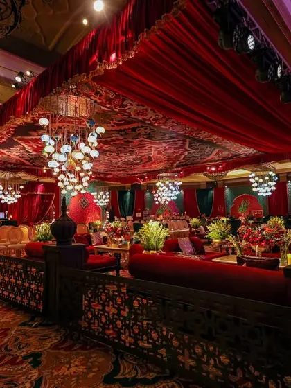 A wide view of the lounge area, defined by custom-carved partitions and a ceiling of red fabric and intricate prints. The space is designed to feel both grand and intimate, perfect for a night of music and celebration.