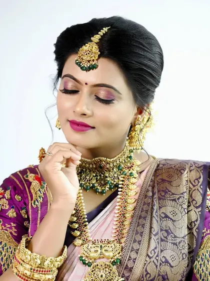 A classic bridal portrait showcasing a flawless makeup look, paired with a traditional saree and authentic temple jewelry.