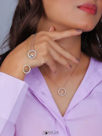 A creative shot showing a model holding her hands up to display three different circular necklaces. This is an effective way to showcase product variations in a lifestyle context.