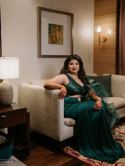 A relaxed portrait. Even when seated, the bride exudes glamour and elegance with her striking makeup and outfit.