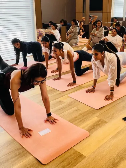 A group of women, including expectant mothers, perform a quadruped exercise on the mat, a safe and effective move for strengthening the core during pregnancy.