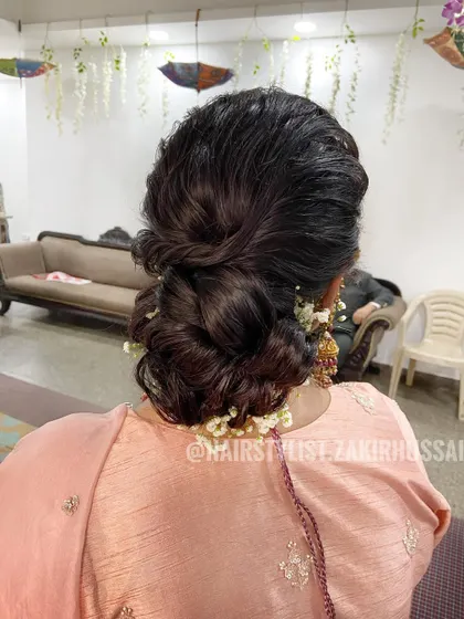 A soft and romantic low bun with baby's breath, perfect for an elegant evening look. The texture gives it a modern, effortless feel.