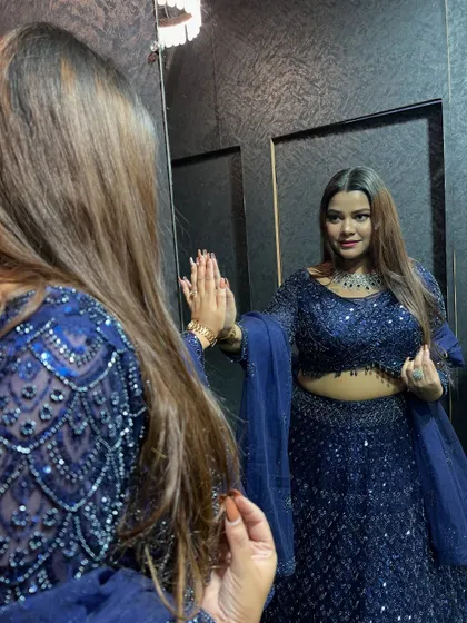 A client admiring her reflection in our popular navy blue sequin lehenga.