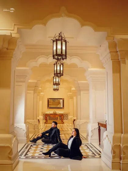 A symmetrically composed shot of the couple in a grand, illuminated hallway. This image is all about clean lines, architectural beauty, and sophisticated style.