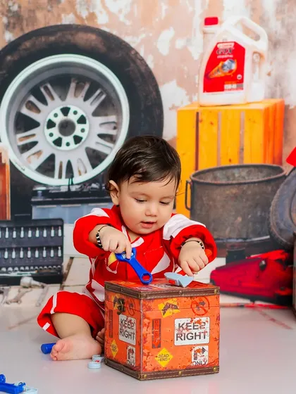 This tiny mechanic is hard at work, carefully examining the parts. The rustic garage backdrop and props create a very authentic feel.