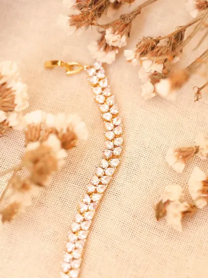 A flat-lay style shot of a diamond bracelet among dried flowers. This romantic, soft styling is great for social media content and brand storytelling.