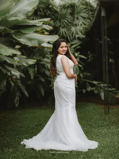 A full-length portrait of the bride, her pose elegant and her smile happy, showcasing her beautiful gown.