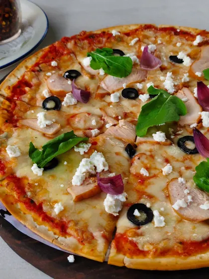 This pizza comes loaded with chicken, black olives, red onions, and feta cheese. A Mediterranean dream.