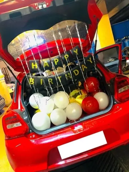 A birthday surprise on the go! A car boot filled with balloons and a 'Happy Birthday' sign is a fun and unexpected way to celebrate.